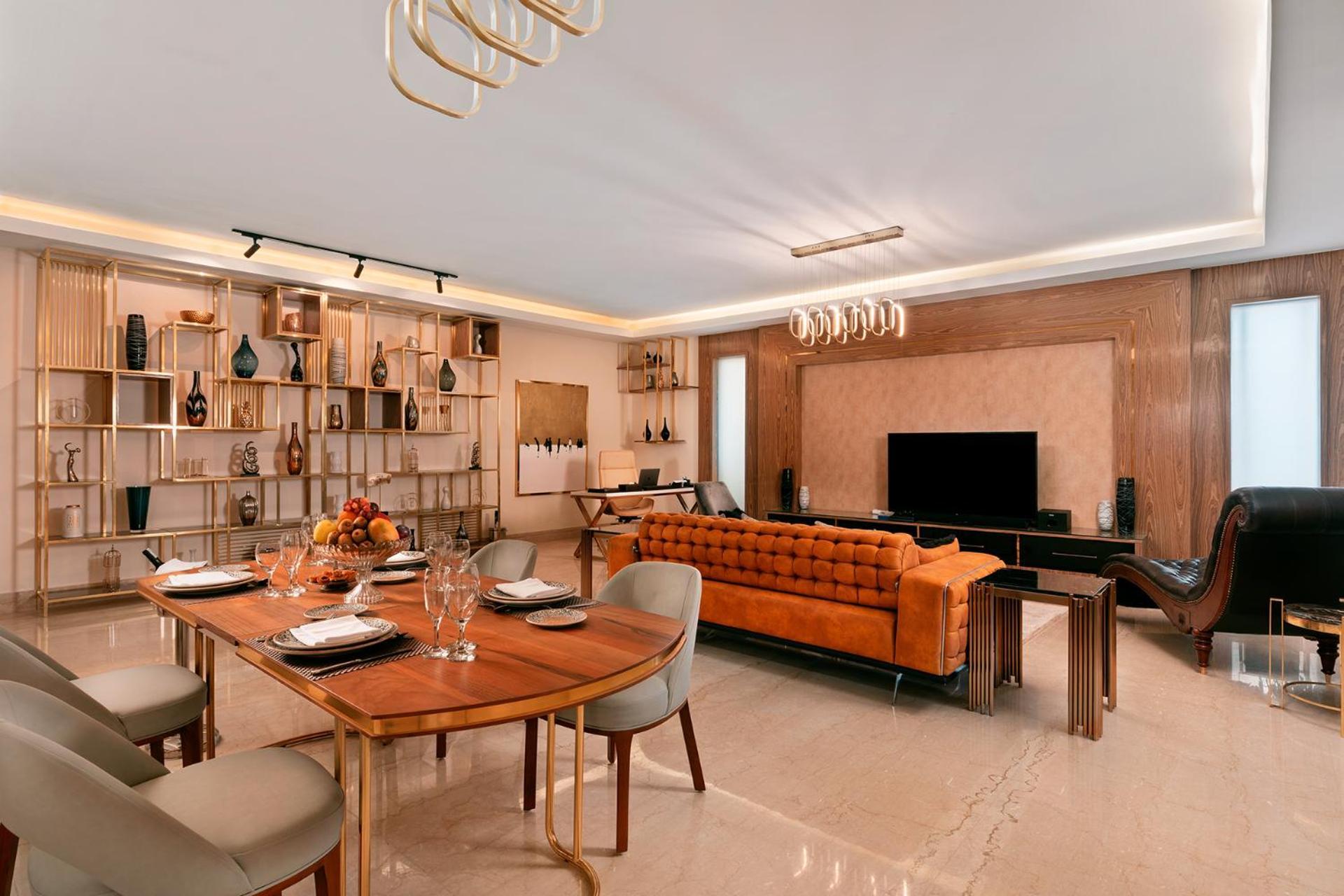 Pickalbatros Citadel Resort Sahl Hasheesh (Adults Only) Hurghada Exterior foto The photo shows a modern living space that features a stylish dining area and a cozy lounge. 

- **Dining Area**: A round dining table is set with plates and glasses, accompanied by chairs. There is a bowl of fruit in the center of the table.
  
- **